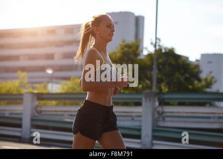 Young female runner running on urban rooftop Stock Photo