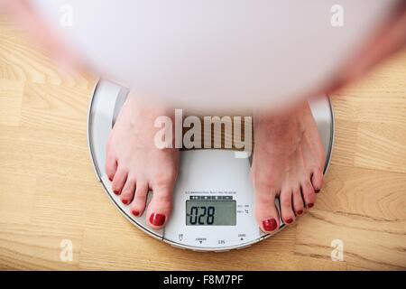 Pregnant woman standing on scales, overhead view Stock Photo