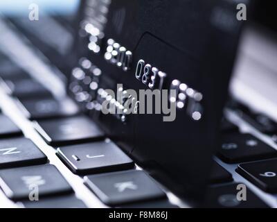 Close up of black credit card standing on computer keyboard Stock Photo