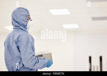 Scientist carrying tray of test tubes in laboratory