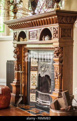 The home of designer Erica Pols. The fireplace in the sitting room. Carved wood, decorated in the Victorian style of the 19th century. Stock Photo