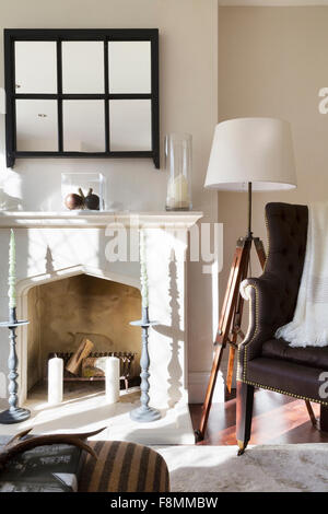 Grade II Listed Country Lodge in Weybridge. The fireplace with ornamental candlesticks in the sitting room Stock Photo
