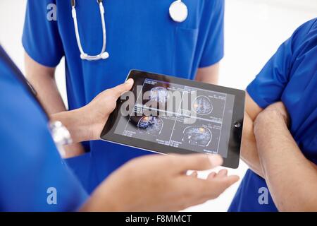 Doctors looking at scans on digital tablet Stock Photo