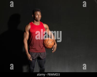 Portrait of basketball player with ball, black background Stock Photo