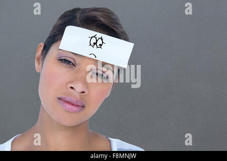 Composite image of portrait of upset woman with blank note on forehead Stock Photo