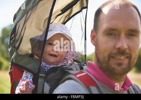Father carrying baby daughter on back Stock Photo