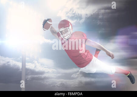 Composite image of american football player scoring a touchdown Stock Photo