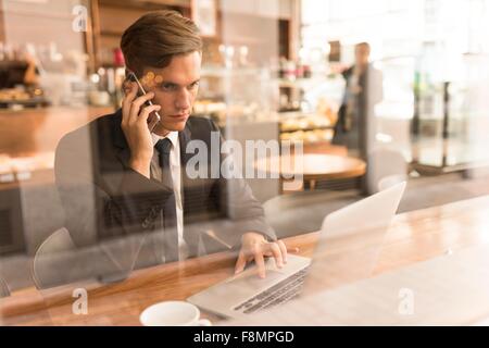 Businessman working on laptop in cafe Stock Photo