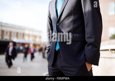 Businessman with hands in pocket, partially obscured, London, UK Stock Photo