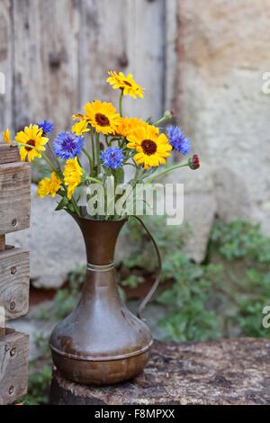 Fresh flowers in metal jug, outdoors Stock Photo