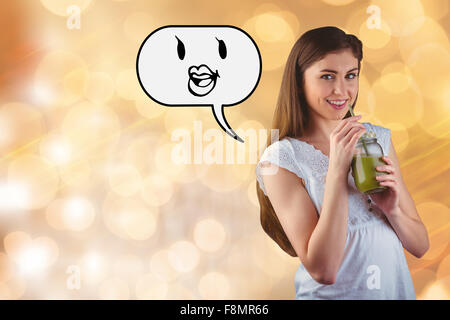 Composite image of pretty woman sipping on green juice Stock Photo