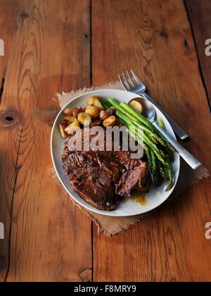 Veal chop with asparagus and potatoes Stock Photo
