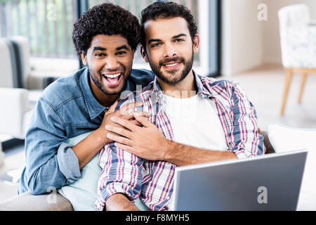 Happy gay couple using laptop Stock Photo