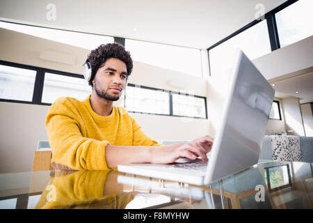 Attractive man using headphones and laptop Stock Photo