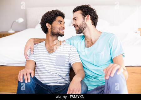 Happy gay couple sitting on the floor Stock Photo