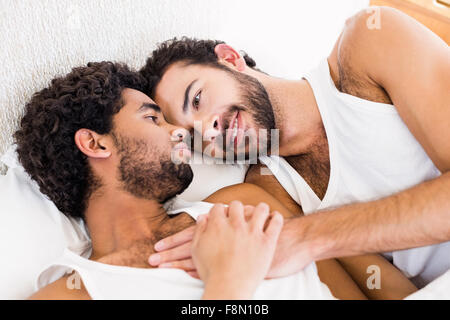 Happy gay couple laying on bed Stock Photo