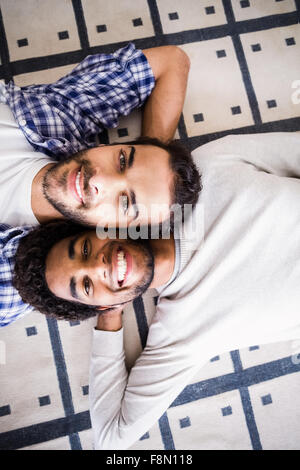 Happy gay couple laying on floor Stock Photo