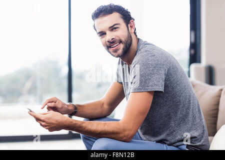 Smiling man using smartphone Stock Photo
