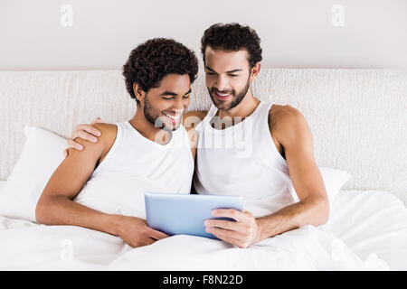 Happy gay couple using tablet Stock Photo
