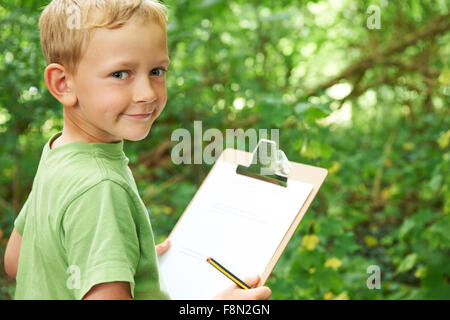 Boy Making Notes On School Nature Field Trip Stock Photo