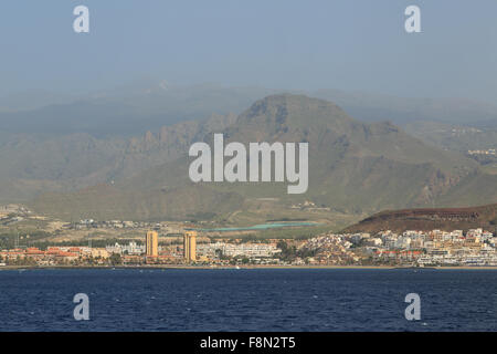 A photograph of Los Cristianos in Tenerife as seen from sea looking towards the mountains. Stock Photo