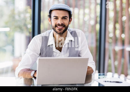 Smiling man using laptop Stock Photo