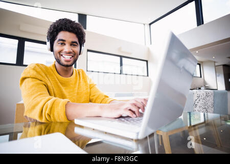 Happy man using headphones and laptop Stock Photo