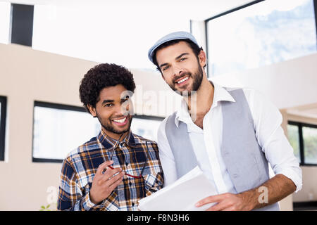 Smiling gay couple holding document posing for camera Stock Photo