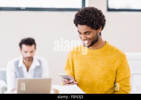 Smiling man holding document using smartphone Stock Photo