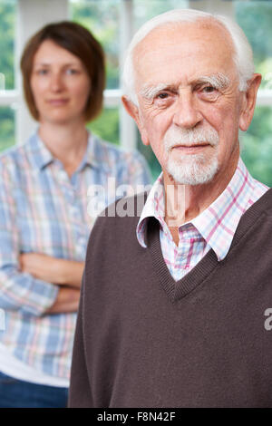 Serious Senior Man With Adult Daughter At Home Stock Photo