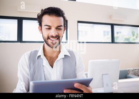 Smiling man using tablet in living room Stock Photo