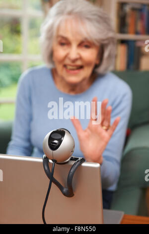 Senior Woman Using Webcam To Talk With Family Stock Photo