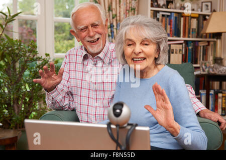 Senior Couple Using Laptop And Webcam To Talk To Family Stock Photo