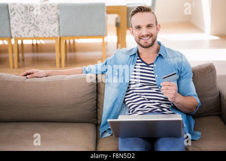 Casual man using laptop on sofa Stock Photo