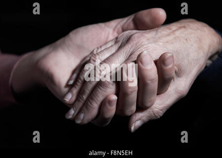 Young Woman Holding Older Woman's Hand Stock Photo