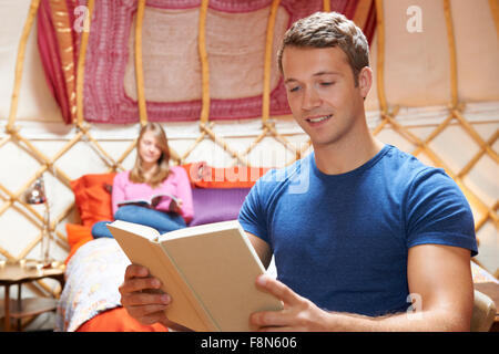Couple Relaxing On Holiday In Yurt Stock Photo
