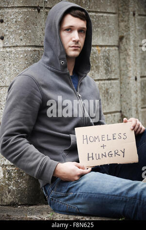 Homeless man begging on the street along 5th Avenue in New York City