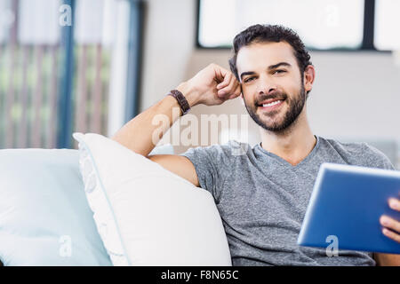 Handsome man using tablet smiling at camera Stock Photo