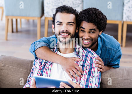 Happy gay couple using tablet Stock Photo
