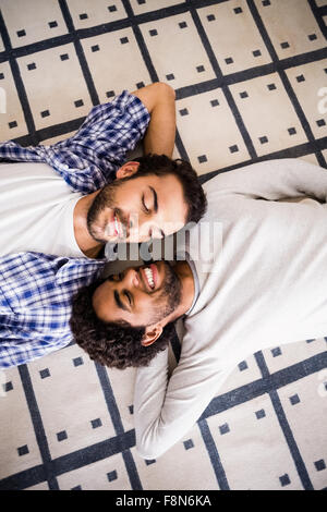 Happy gay couple laying on floor Stock Photo