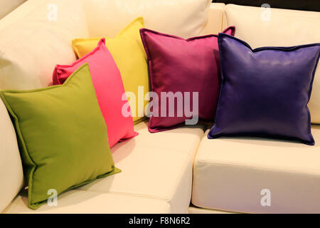 Pillows of different colors on the leather sofa. Stock Photo
