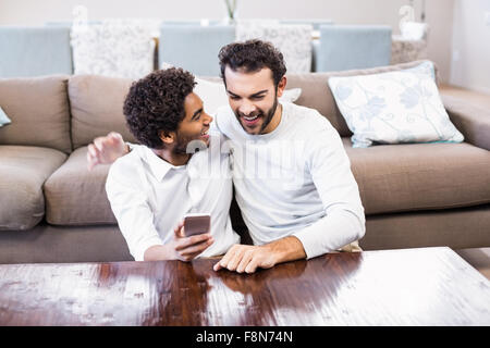 Happy gay couple using smartphone Stock Photo