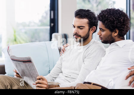 Gay couple reading newspaper Stock Photo