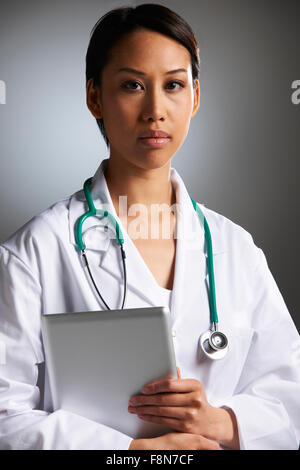 Studio Shot Of Doctor Using Digital Tablet Stock Photo