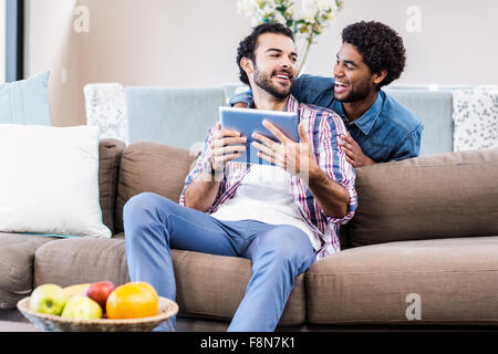 Happy gay couple using tablet Stock Photo
