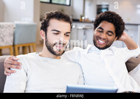 Happy gay couple using tablet Stock Photo
