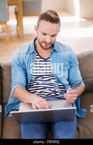 Casual man using laptop on sofa Stock Photo