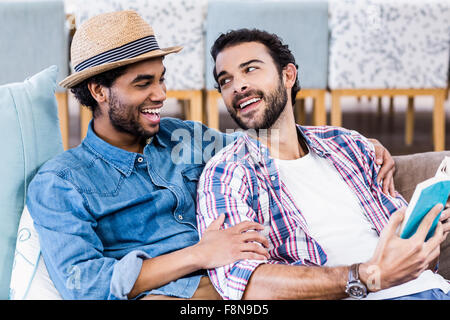 Happy gay couple reading book Stock Photo