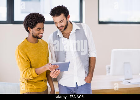 Smiling gay couple using tablet Stock Photo