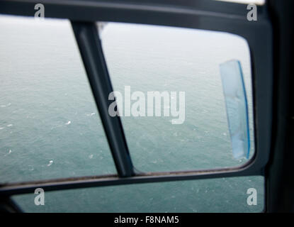 in the cockpit of a helicopter flying from the mainland to Lundy Island, view out the side of the sea Stock Photo